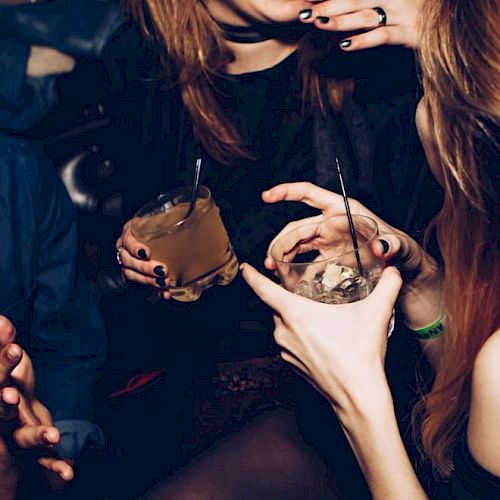 People are enjoying drinks and laughing in what appears to be a lively social setting.