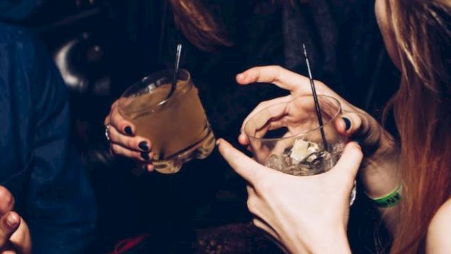 People are enjoying drinks and laughing in what appears to be a lively social setting.